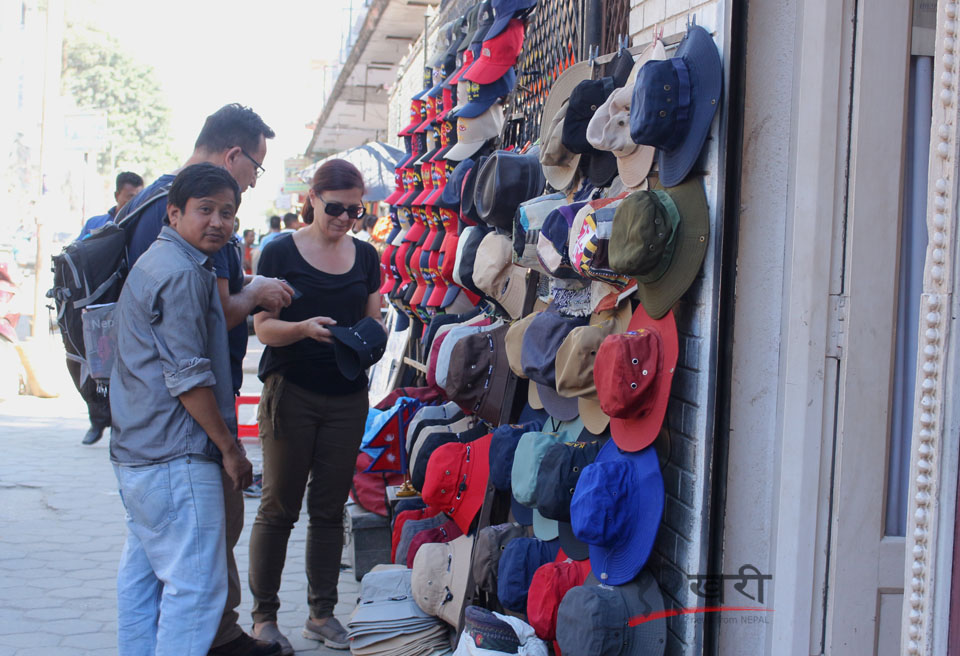 राजधानीको ठमेलमा फुटपाथमा राखिएका नेपाली ह्याट किन्दै विदेशी पर्यटक । तस्बिर : सरिता खड्का