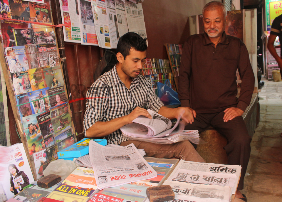 काठमाडौं असनको गल्लिमा नेवारी भाषामा प्रकाशित पत्रिका बेच्दै व्यापारी । तस्बिर : बाह्रखरी ।