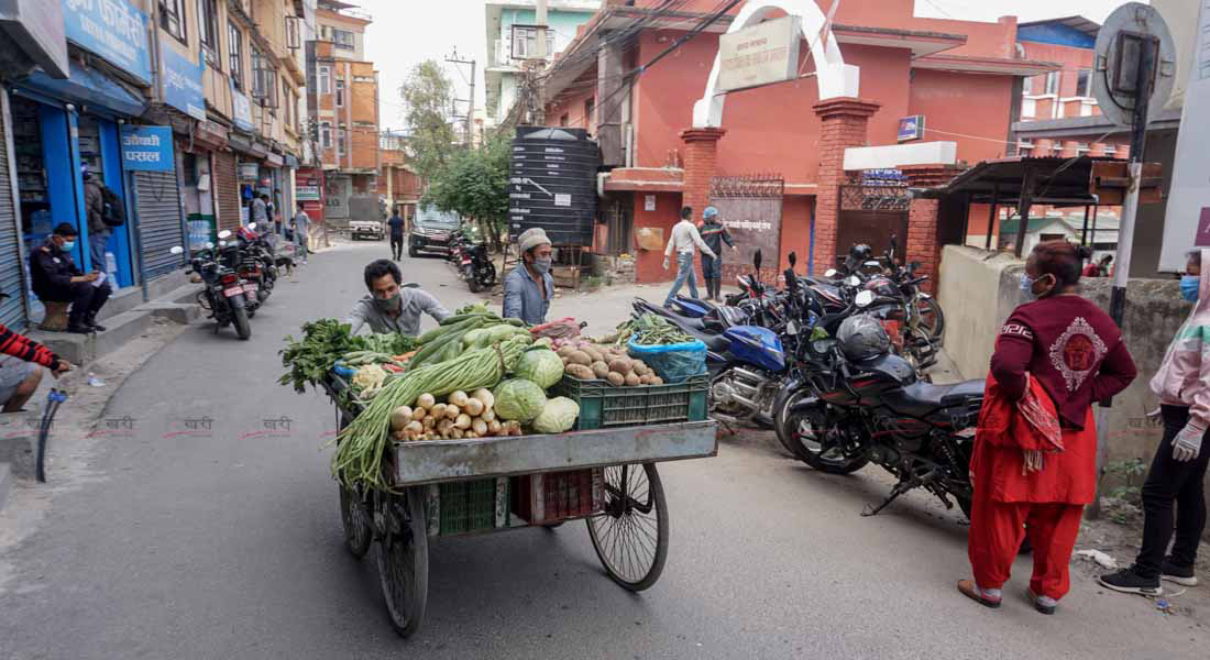 काठमाडौंको टेकु क्षेत्रमा ठेलागाडामा तरकारी बेच्‍न हिँडेका एक व्यापारी । तस्बिर : सुनील प्रधान/बाह्रखरी