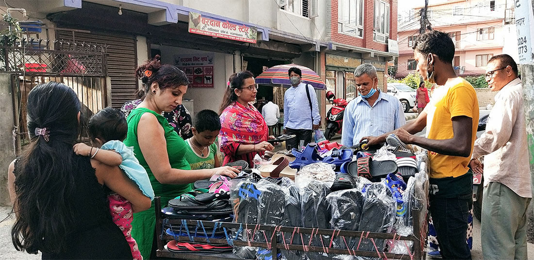 ठेलामा व्यापार : काठमाडौंको नयाँ बानेश्‍वरस्थिति मिलिजुली चोकमा ठेलामा जुत्ता-चप्पलको कारोबार गर्दै ग्राहक र व्यापारी । तस्बिर : बाह्रखरी