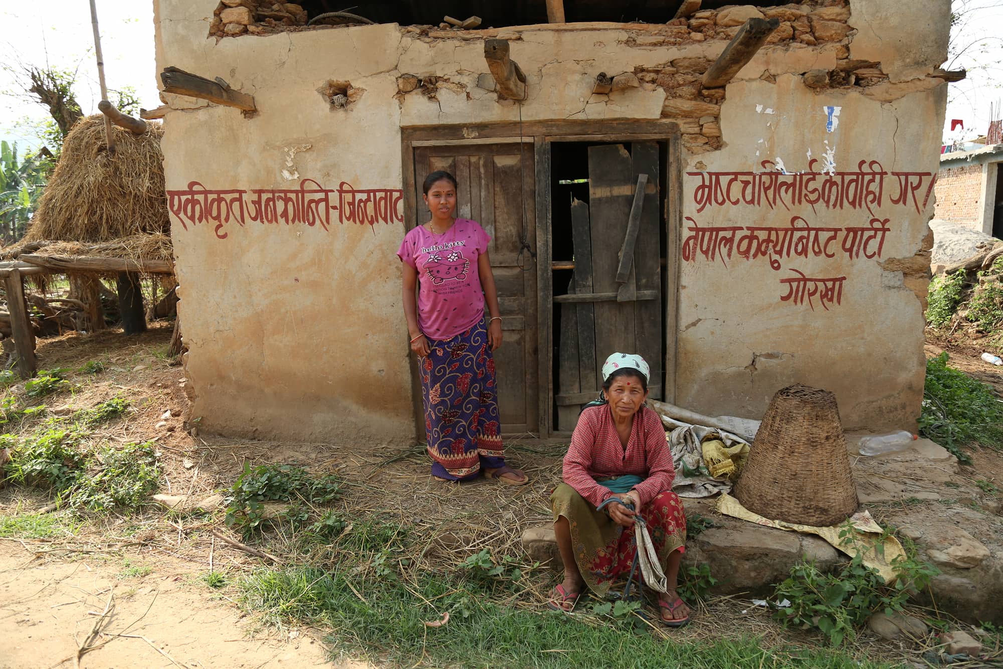 गोरखाको चोरकाटे टारमा भूकम्पले भत्किएको घरअघि थकाइ मार्दै स्थानीय महिला । तस्बिरः सरिता खड्का