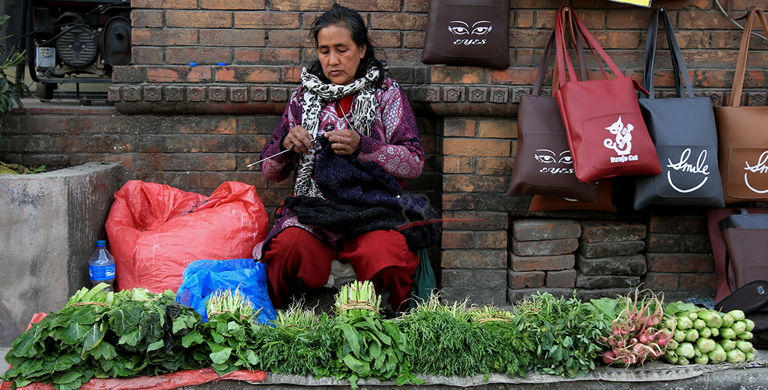 कामसँगै व्यापार : काठमाडौंको जमलमा तरकारी बेच्न बसेकी एक महिला फुर्सदमा स्वेटर बुन्दै । तस्बिर : हरिशजंग क्षेत्री/बाह्रखरी